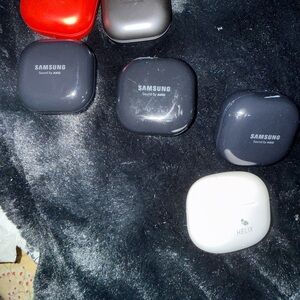 Samsung Earbud Charging Cases in Black, White, Red, and Silver with 2 earbuds.